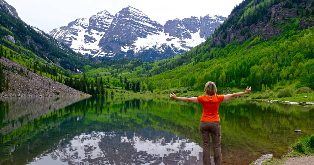 Woman Standing by Lake in Maroon Bells
