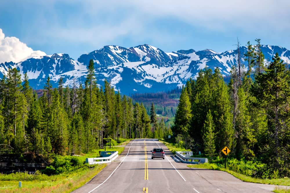 Two lane road heading toward a range of mountains in Wyoming. 