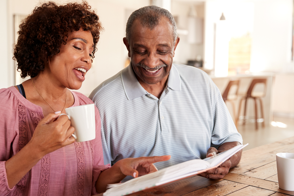 Senior man and daughter looking through photo album together