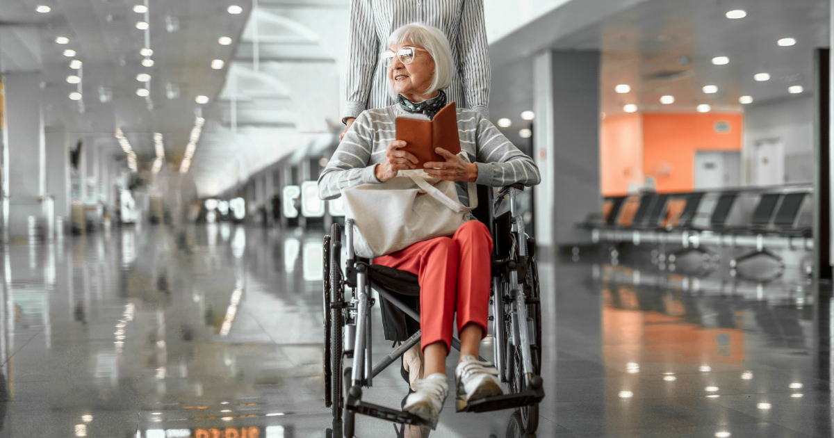 senior woman traveling in wheelchair in airport