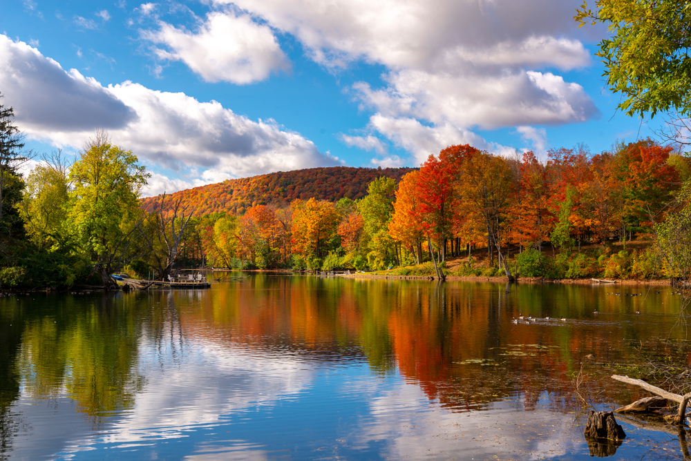 Adirondacks in upstate NY. Mirror Lake in Lake Placid, New York, on a sunny autumn day with colorful fall foliage on the mountains in the background